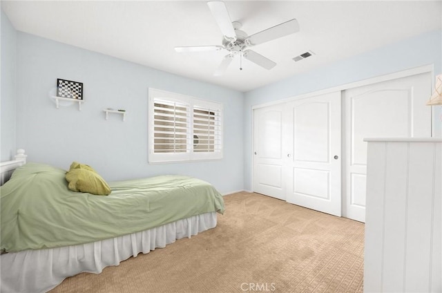 bedroom with a closet, carpet, visible vents, and ceiling fan