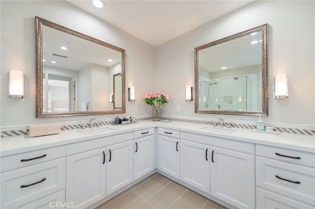 full bath with double vanity, visible vents, a stall shower, and a sink