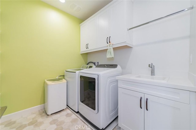 laundry area with washing machine and clothes dryer, visible vents, baseboards, cabinet space, and a sink