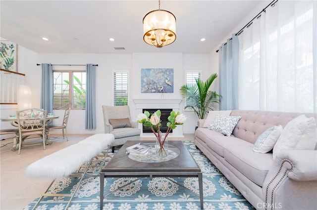 living room featuring recessed lighting, visible vents, a notable chandelier, and a fireplace