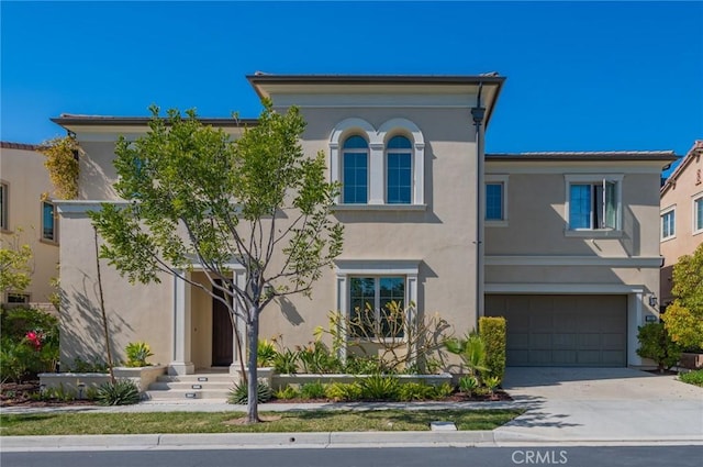 view of front of home featuring concrete driveway, an attached garage, and stucco siding