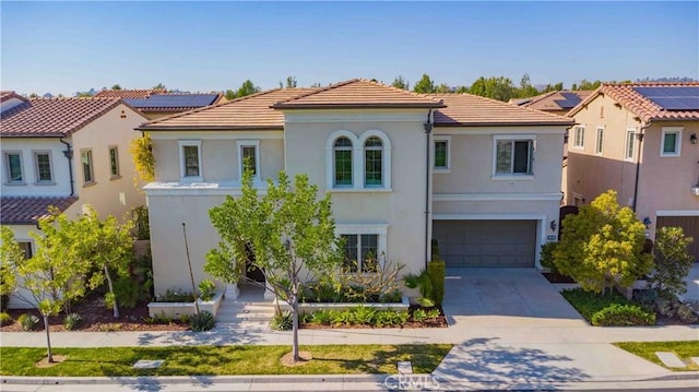 mediterranean / spanish-style home featuring a tile roof, stucco siding, an attached garage, and concrete driveway