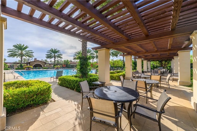 view of patio / terrace featuring outdoor dining space, a pergola, and a community pool