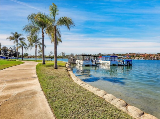 view of dock featuring a lawn and a water view