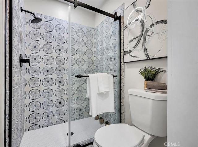 bathroom with a shower stall and toilet