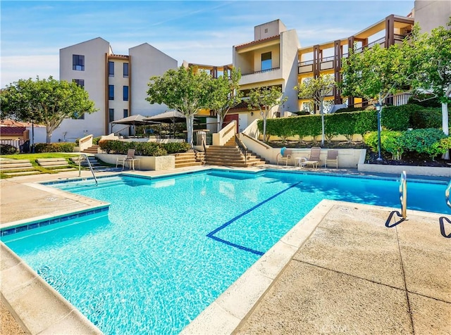 community pool with stairs and a patio