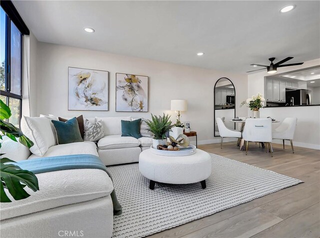 living room featuring recessed lighting, baseboards, light wood-style floors, and ceiling fan