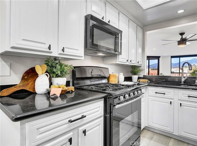 kitchen featuring a sink, black appliances, white cabinets, and ceiling fan