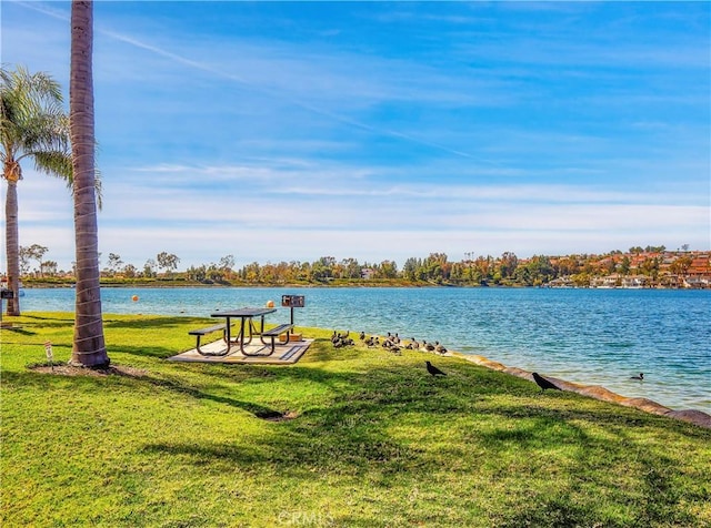 view of property's community featuring a yard and a water view