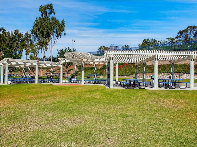 view of community with a pergola and a yard