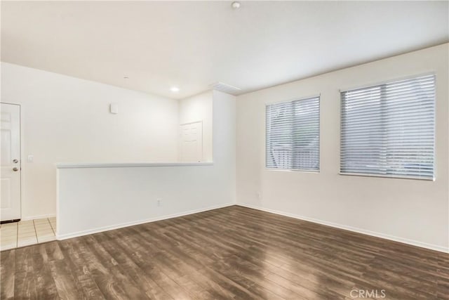 spare room with wood finished floors and baseboards