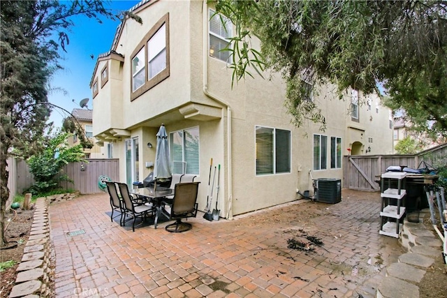 back of property with cooling unit, stucco siding, a patio, and a fenced backyard