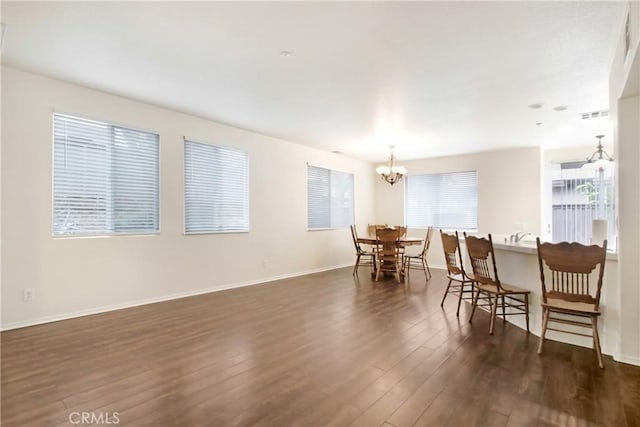 dining room with dark wood finished floors, visible vents, baseboards, and an inviting chandelier