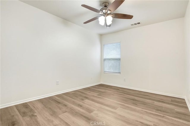 unfurnished room with light wood finished floors, visible vents, ceiling fan, and baseboards