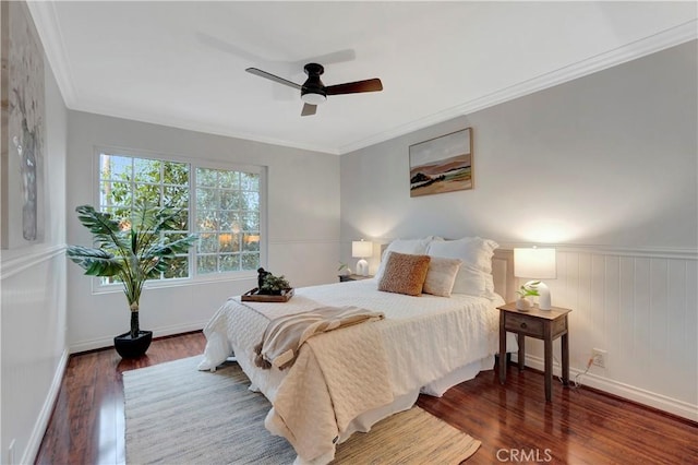 bedroom featuring crown molding, wood finished floors, baseboards, and ceiling fan