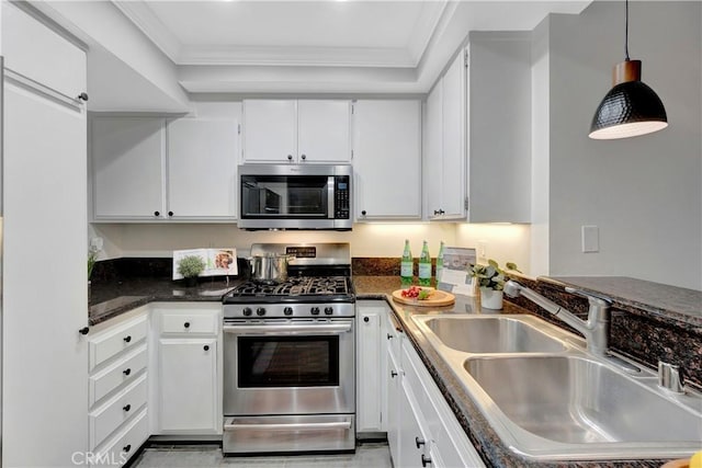 kitchen featuring a sink, hanging light fixtures, ornamental molding, stainless steel appliances, and white cabinetry