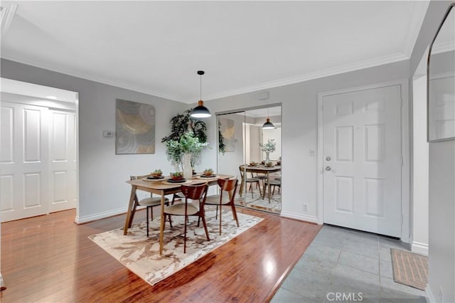 dining area with baseboards, light wood-style floors, and ornamental molding