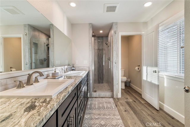 full bathroom featuring a sink, visible vents, toilet, and a shower stall