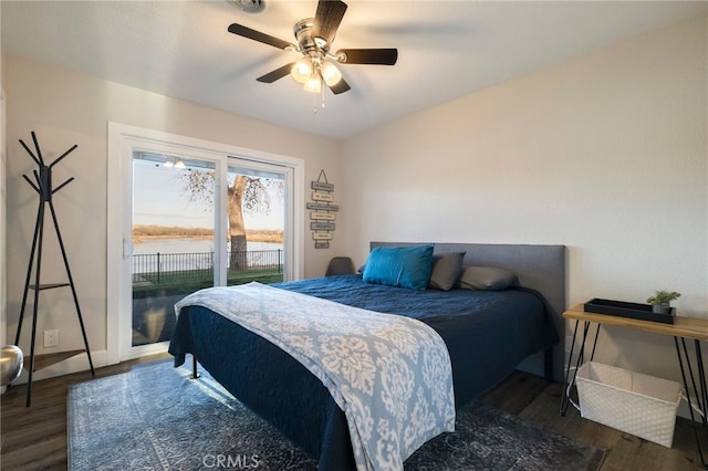 bedroom featuring baseboards, a water view, ceiling fan, wood finished floors, and access to outside