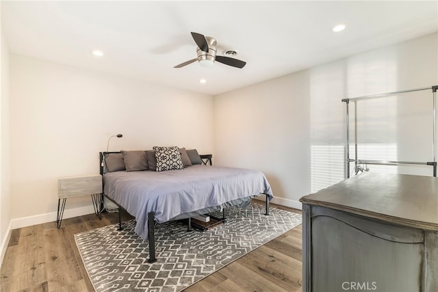 bedroom with recessed lighting, wood finished floors, and baseboards