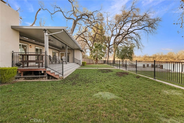 view of yard with ceiling fan, a wooden deck, and a fenced backyard