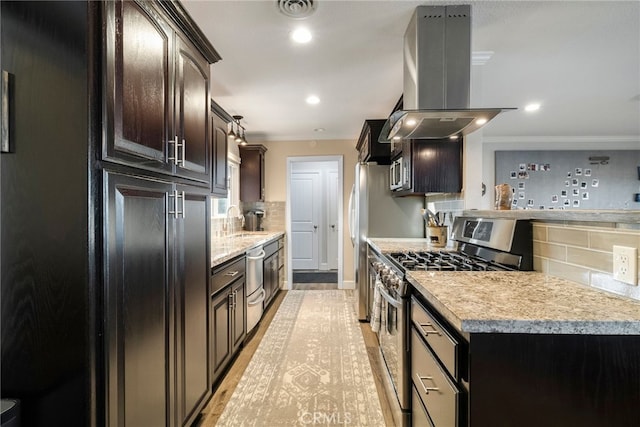 kitchen featuring island exhaust hood, a sink, stainless steel appliances, light countertops, and backsplash