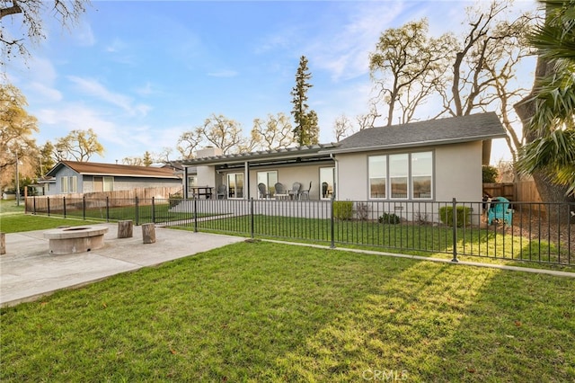 back of property featuring a patio, a yard, stucco siding, a fire pit, and fence private yard