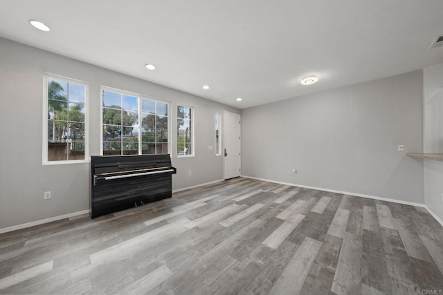 interior space with recessed lighting, baseboards, a healthy amount of sunlight, and wood finished floors