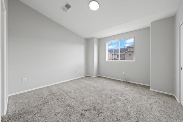 empty room with lofted ceiling, carpet flooring, baseboards, and visible vents