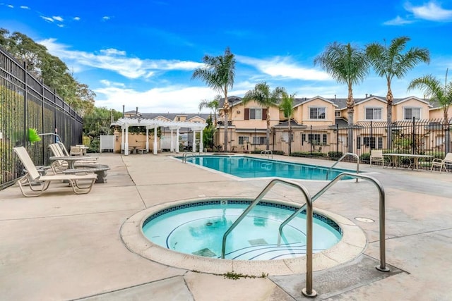 pool with a pergola, a patio, fence, a residential view, and a hot tub