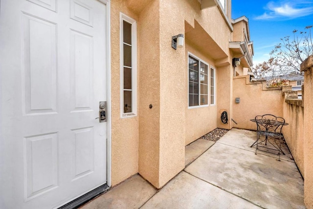 doorway to property featuring a patio area and stucco siding