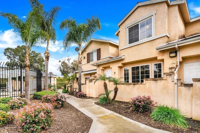 exterior space featuring stucco siding and fence