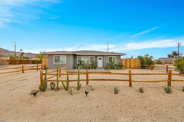 ranch-style house with fence and stucco siding