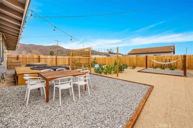 view of yard featuring a mountain view, a patio, outdoor dining area, and a fenced backyard