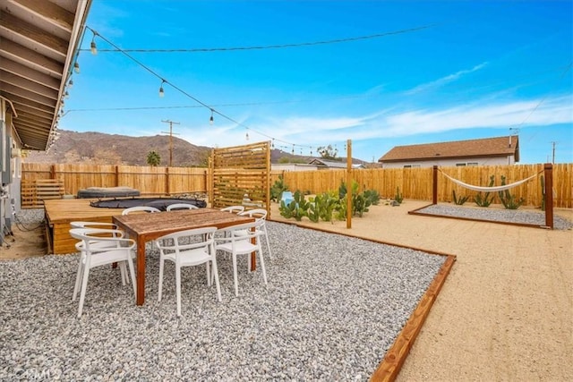6566 El Rey Ave Unit 29, Palms, CA 92277 - view of yard with a mountain view, a fenced backyard, outdoor dining space, and a patio
