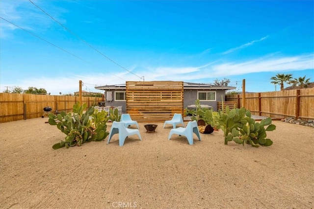 6566 El Rey Ave Unit 29, Palms, CA 92277 - rear view of house with an outdoor fire pit, a patio, roof mounted solar panels, and a fenced backyard