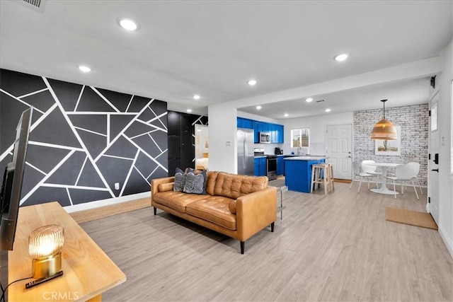 living area featuring recessed lighting, light wood-type flooring, and an accent wall