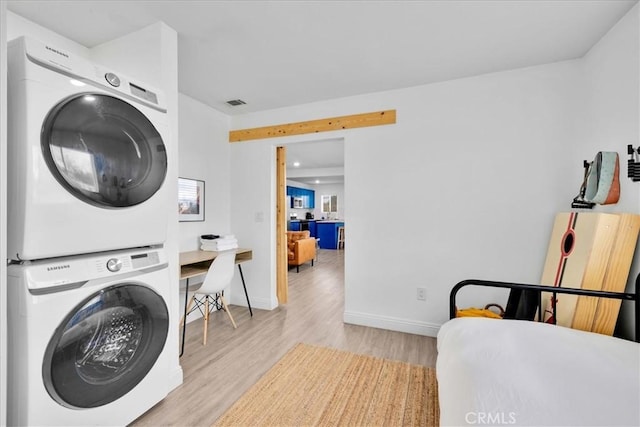 6566 El Rey Ave Unit 29, Palms, CA 92277 - laundry room with visible vents, baseboards, stacked washer / dryer, laundry area, and light wood-style flooring