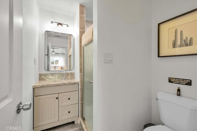 full bathroom featuring a stall shower, toilet, and vanity