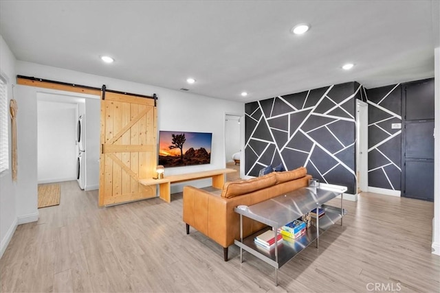 living room with a barn door, recessed lighting, wood finished floors, and baseboards