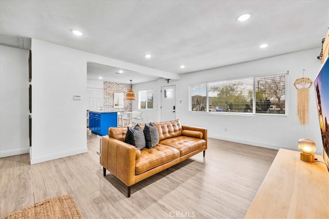 living room featuring recessed lighting, baseboards, and light wood-style flooring