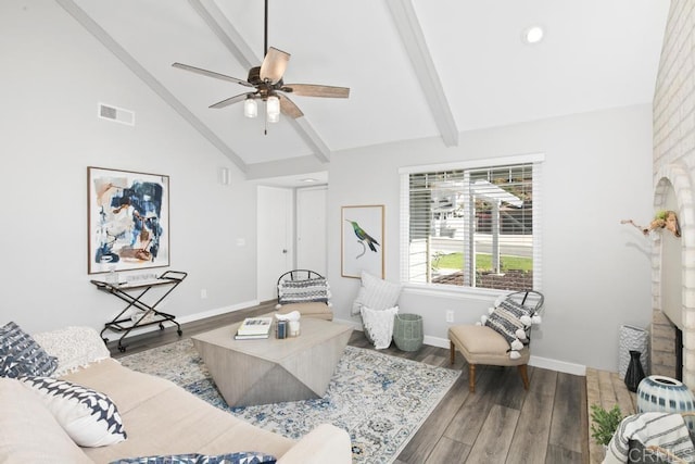 living area with beamed ceiling, wood finished floors, visible vents, and ceiling fan