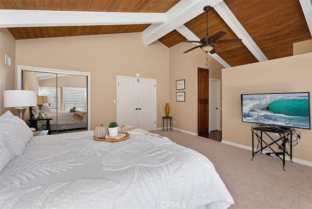 bedroom with vaulted ceiling with beams, baseboards, carpet, multiple closets, and wooden ceiling