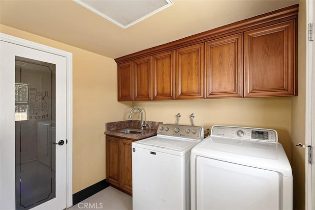 laundry area with washing machine and clothes dryer, cabinet space, baseboards, and a sink