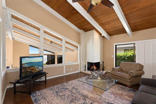 living area with wood finished floors, lofted ceiling with beams, a fireplace, and baseboards