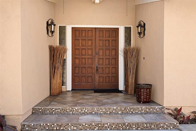 doorway to property featuring stucco siding