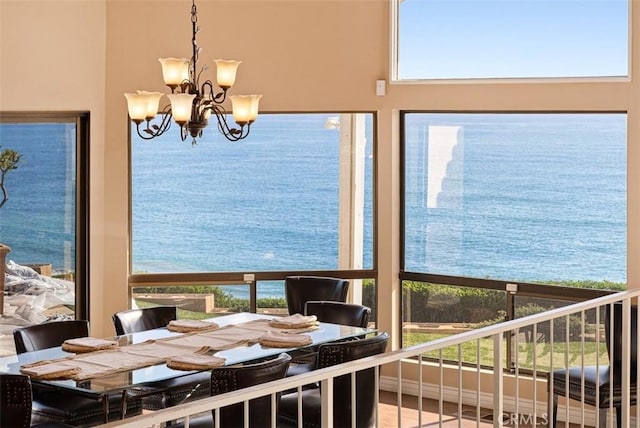 dining room featuring a notable chandelier, a healthy amount of sunlight, and a water view