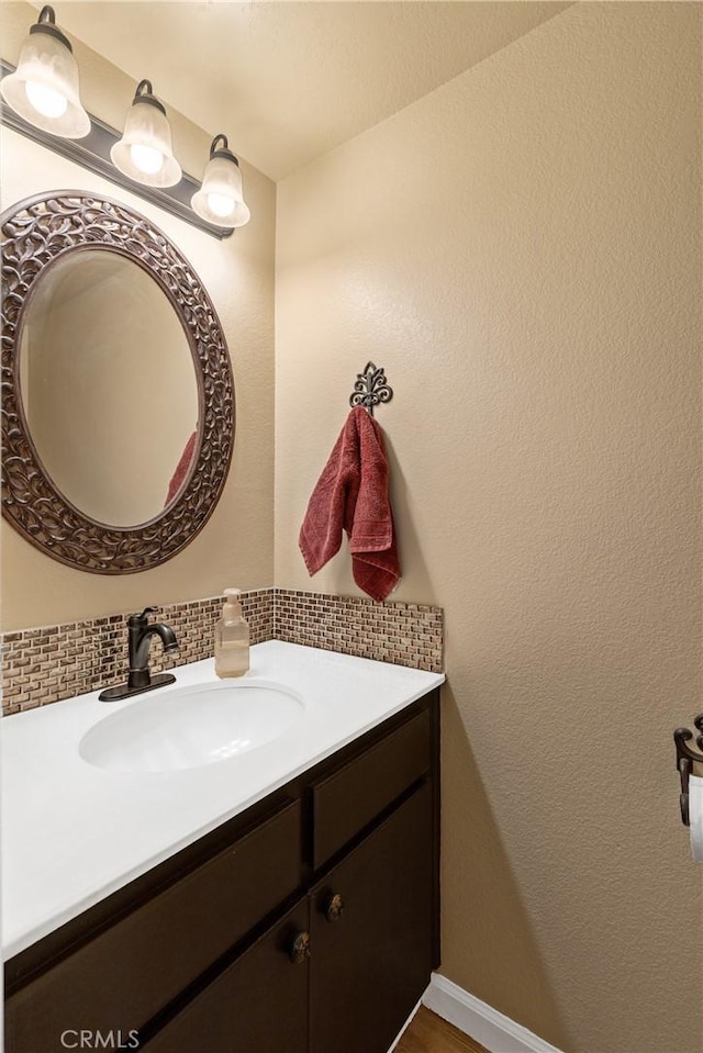 bathroom featuring vanity and decorative backsplash