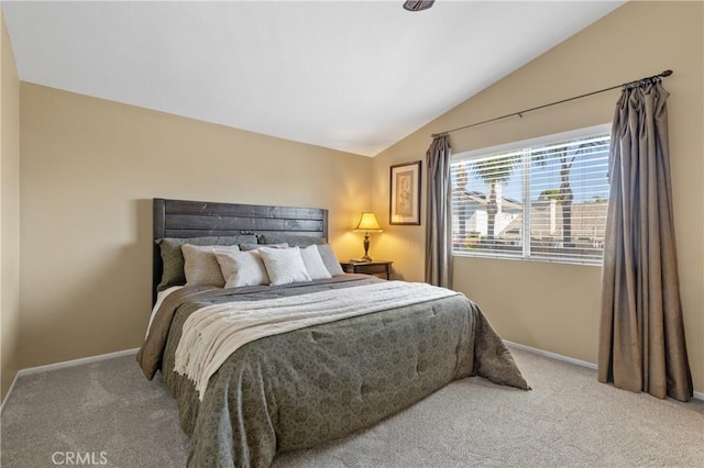 carpeted bedroom with baseboards and vaulted ceiling