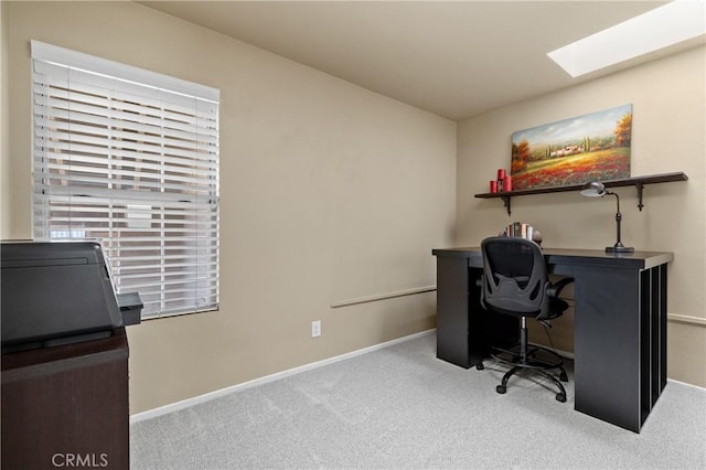 office space with a skylight, carpet flooring, and baseboards